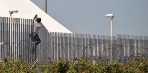 A guest of the centre jumps over the fence of the Cara in Bari, Italy