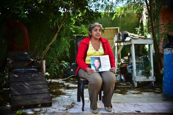 A woman holding a picture of her disappeared daughter 