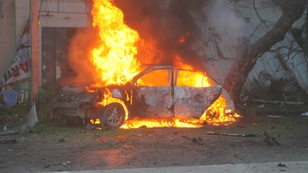 A car burns in the Somali capital after the explosion in the city centre