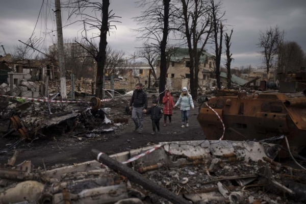  An Ukrainian family walks through the rubble of their city