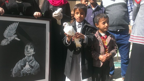  Un bambino cieco yemenita con una colomba ad una manifestazione contro un attacco nella capitale