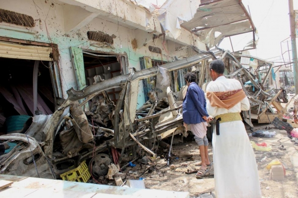 Spettatori guardano i detriti lasciati dopo che uno scuolabus è stato bombardato dall’esercito dell’Arabia Saudita in Yemen