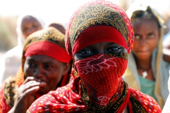 Una donna etiope indossa un niqab rosso e guarda verso la fotocamera