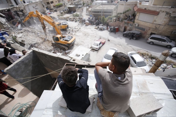Two Palestinenan boys look down over their demolished housing complex