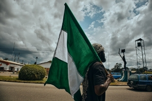 Un manifestante porta la bandiera nazionale a Port Harcourt, Nigeria