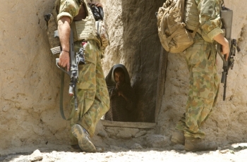 Afghan child hiding amongst soldiers in Afghanistan