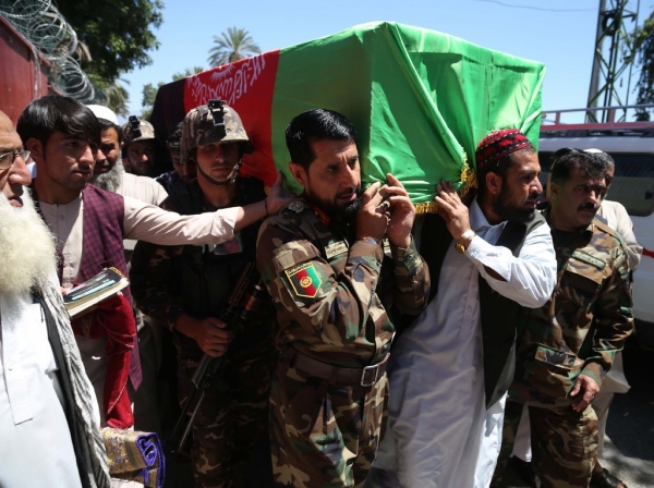 The coffin of Samiullah Rayhan, a religious scholar who was killed while leading prayers at a Mosque in Kabul on 24 May, is carried by Afghan soldiers and supporters.