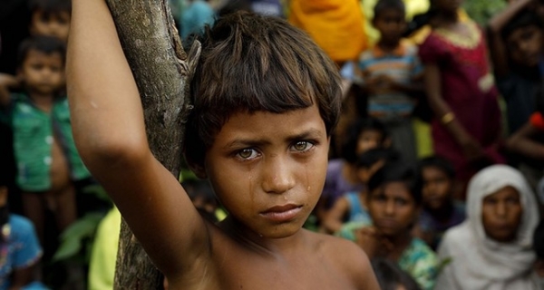 A young Rohingya girl stands in a refugee camp in Bangladesh after fleeing Myanmar 