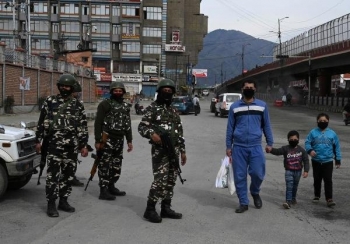 A family walks wearing facemasks in Srinagar, Kashmir