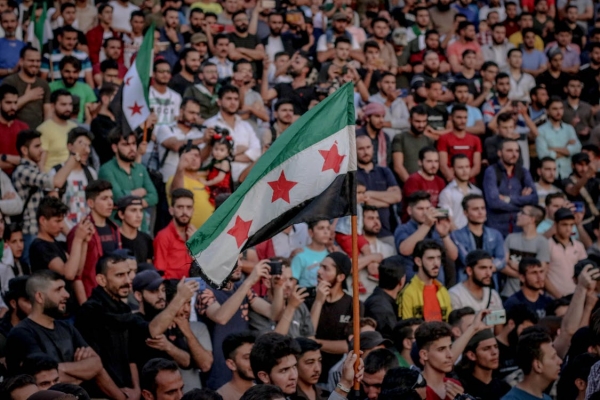 La bandiera siriana sventola al di sopra di una folla di persone