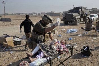 An American volunteer medic treats a wounded Iraqi girl 