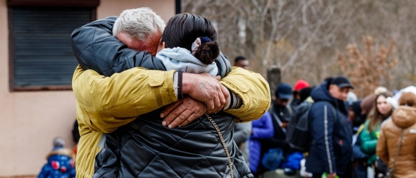 Ukrainian refugees hugging each other at a checkpoint on the border of Slovakia. 