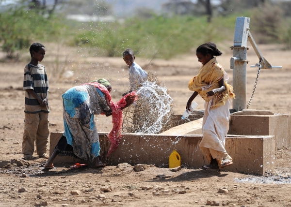 Ethiopian women playing with their children while getting water