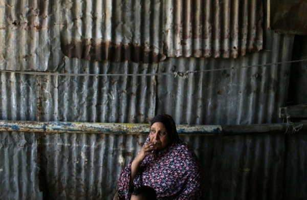 A Palestinian woman sits outside of her house in the Khan Younis refugee camp in southern Gaza.