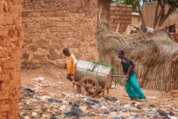 Due ragazzi trasporano il rifornimento di acqua per tutto il villaggio coinvolto negli scontri