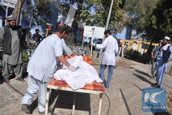 Doctors carrying a wounded man to hospital after the blast in the marketplace 