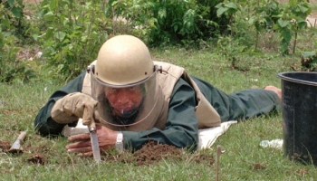 Un tecnico de Laos tasta il terreno in cerca di esplosivi eredita' della guerra segreta.