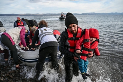 Migrants disembarking a boat after arriving on the Greek island of Lesbos