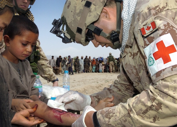 Soldato canadese cura un bambino afgano
