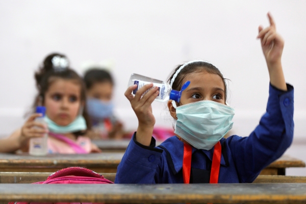 Una bambina rifugiata indossa una mascherina a scuola