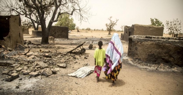 A woman and her child walk through the village Ogossagou after an attack in March 2019 that killed over 150 civilians