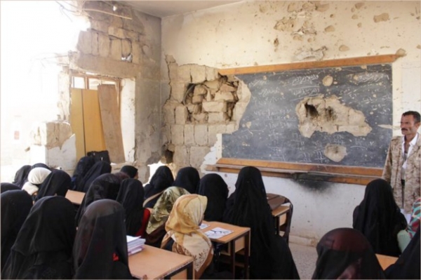 Yemeni children attend school in a war-damaged building 