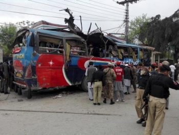 I soccorritori accorrono verso un autobus danneggiato dall&#039;esplosione di una bomba a Peshawar, Pakistan.