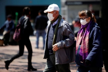 People walk on the street wearing masks in Bogota, Colombia on March 17, 2020