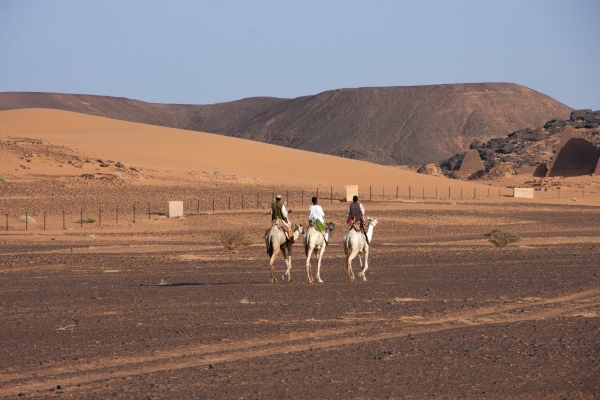 Tre uomini somali a cavallo nel deserto.