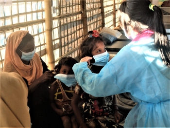  IOM doctor helps a Rohingya family in the Kutupalong refugee camp, Cox’s Bazar, Bangladesh.