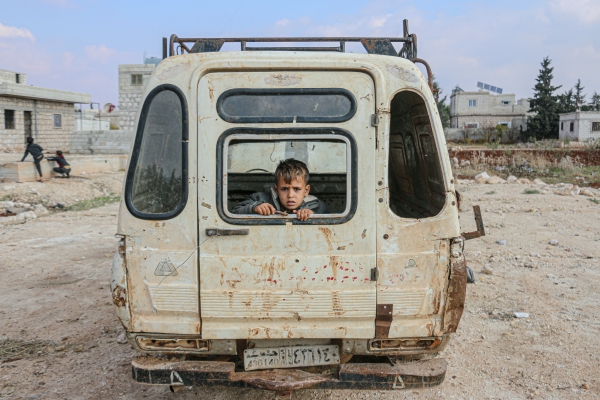 Bambino seduto in un furgone abbandonato in Siria