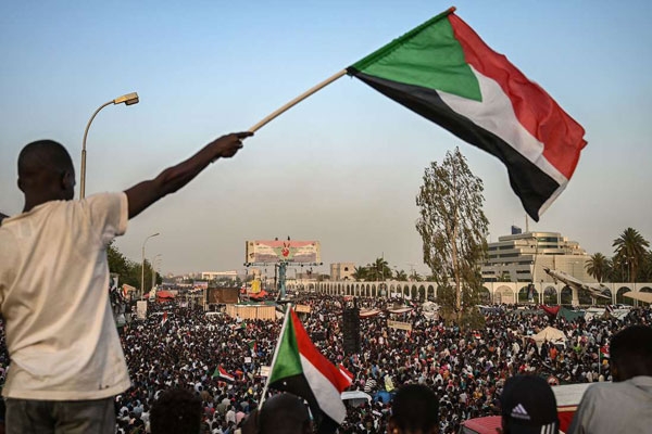 A Sudanese protester with the national flag in Khartoum