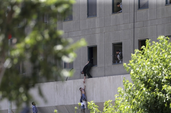A child is escaping from a window during the assault at the Iranian parliament