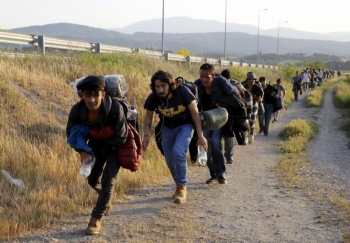 Un gruppo di migranti dalla Syria cerca di evitare il controllo delle pattuglie greche al confine macedone