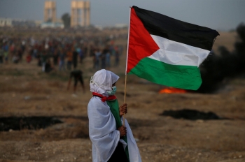 A woman holds a Palestinian flag during a protest in Gaza 