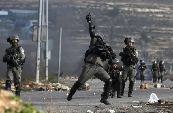 Guardie di frontiera israeliane con protestanti palestinesi il 12 gennaio 2018