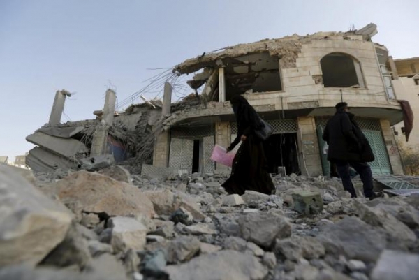 A woman walks past the house of court judge Yahya Rubaid after a Saudi-led air strike destroyed it, killing him, his wife and five other family members on January 25, 2016.