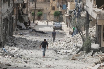 Persone si aggirano intorno agli edifici bombardati nella zona intorno ad Aleppo controllata dai ribelli
