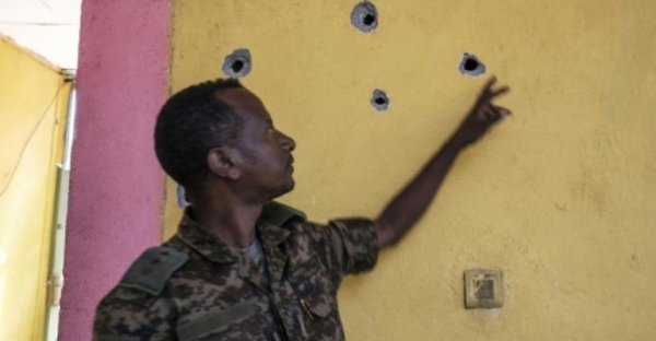 An Ethiopian soldier points to bullet holes left after an attack
