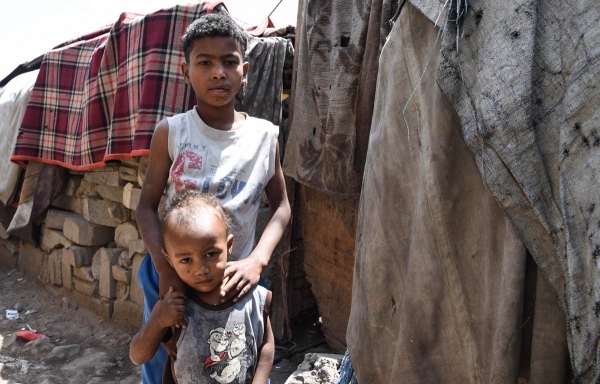 Two brothers stand in a camp for displaced people in Yemen