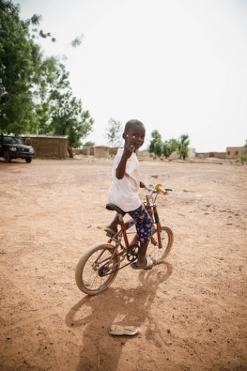 A little Malian girl riding a bicycle. 