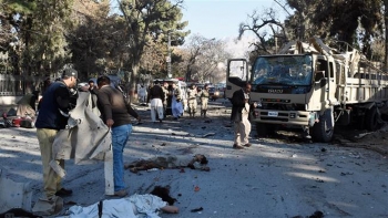 Ufficiali di sicurezza pakistani vicino ai corpi delle vittime di un&#039;esplosione.