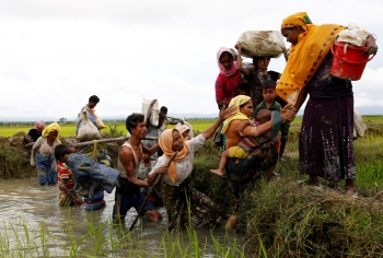 Una dozzina di rifugiati Rohingya viaggia oltre il confine tra il Bangladesh e il Myanmar