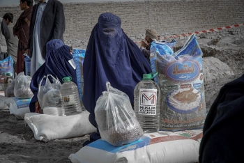 Donne afghane mentre ricevono aiuti umanitari