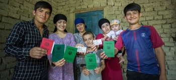 A family shows their new identity documents after obtaining the citizenship