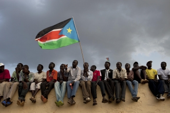 Gli uomini sventolano la bandiera del Sud Sudan durante i negoziati di pace del 2018
