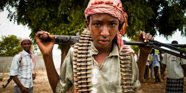 Un giovane soldato di Al-Shabab in posa con la sua arma. A molti dei giovani somali rapiti o reclutati nel gruppo terrorista sono promessi istruzione e denaro per le proprie famiglie 