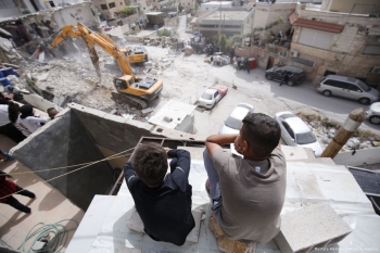 Due bambini palestinesi che guardano le loro case ormai distrutte 
