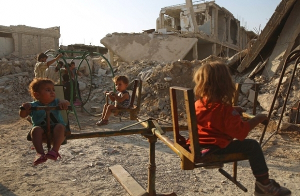 Bambini giocano nella cittadina di Douma, distrutta e controllata dai ribelli, vicino a Damasco