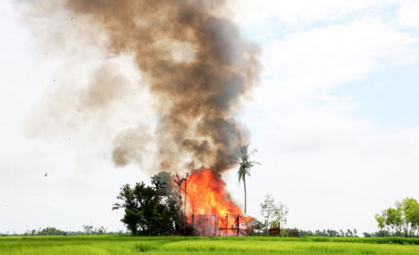 In this 2017 photo, a house burns in Gawdu Tharya village near Maungdaw, Rakhine state